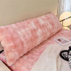 A pink plush long pillowcase resting on a light-colored surface.
