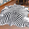 A white rug featuring a black and white zebra stripe pattern on a wooden floor.