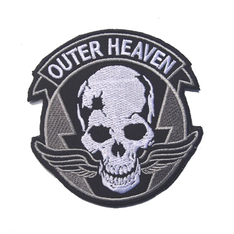 A black and gray embroidered patch with the text OUTER HEAVEN surrounding a white skull and wings.