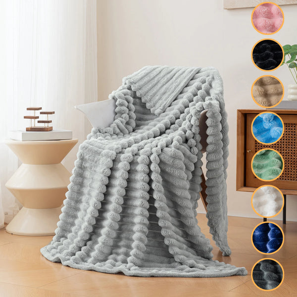 A fluffy gray soft flannel throw blanket draped over a chair in a bright room.