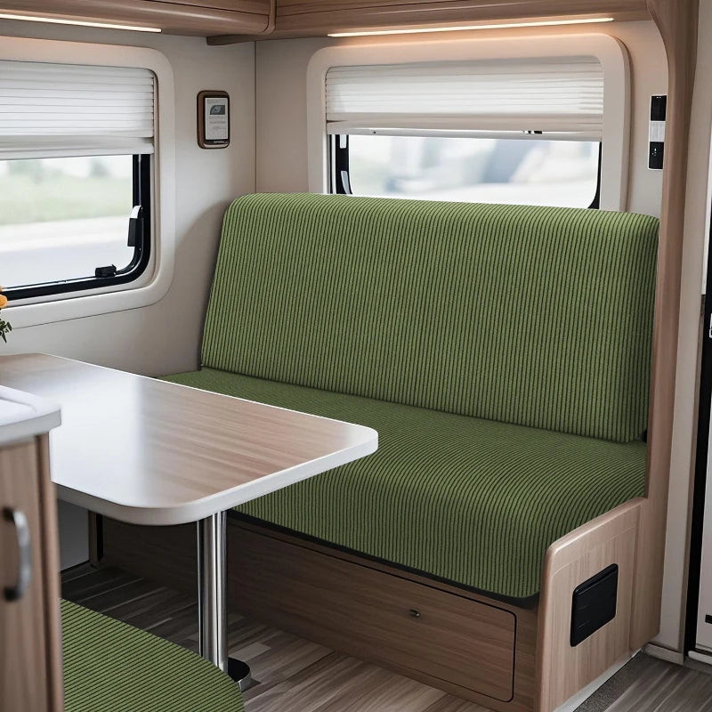 Interior view of an RV featuring a green cushioned dinette seat and a light wood table.