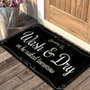 A black laundry mat with white text that reads Wash & Dry or be naked tomorrow, placed on a wooden floor.