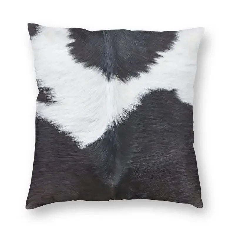 A square cushion cover featuring a black and white cowhide print faux fur design.