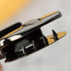 Close-up of a gold metal twist lock mechanism used for securing bags or cases.