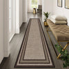 A long rectangular modern geometric area rug in beige and brown tones placed on a wooden floor.