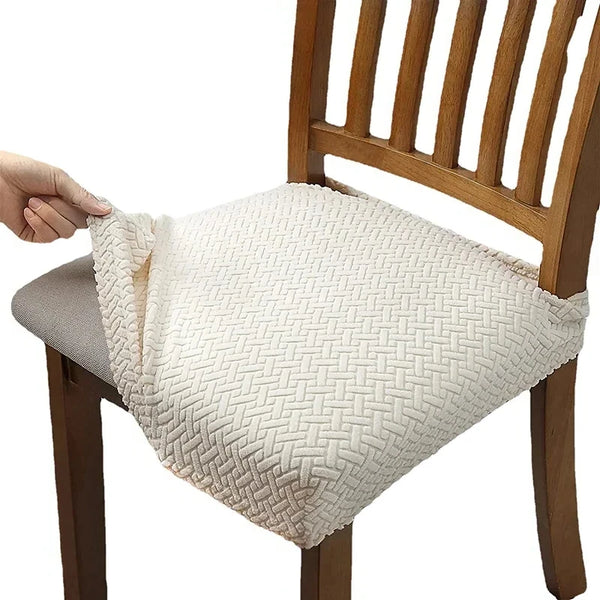 A white woven seat cover is placed on a wooden dining chair.