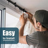 A man installs a flexible bendable curtain track system on a ceiling using a black mounting bar.