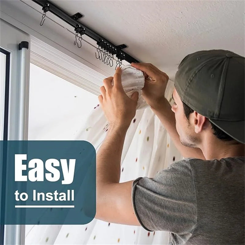 A man installs a flexible bendable curtain track system on a ceiling using a black mounting bar.