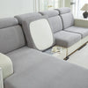 A light gray jacquard elastic sofa cushion slipcover with a white accent cushion shown in a living room setting.