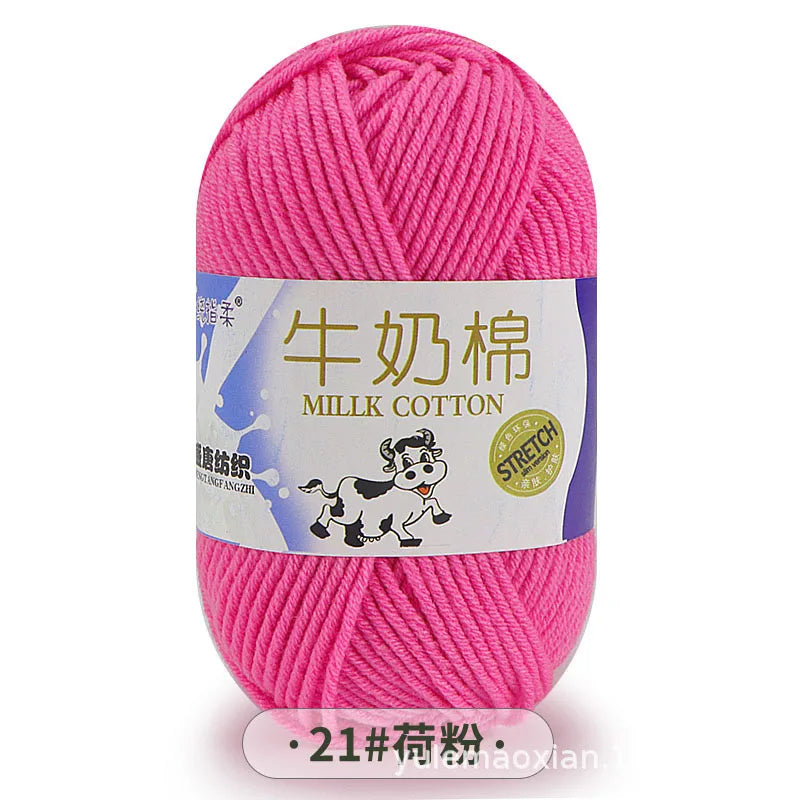 Pink milk cotton yarn skein with a label featuring a dog and stitching details