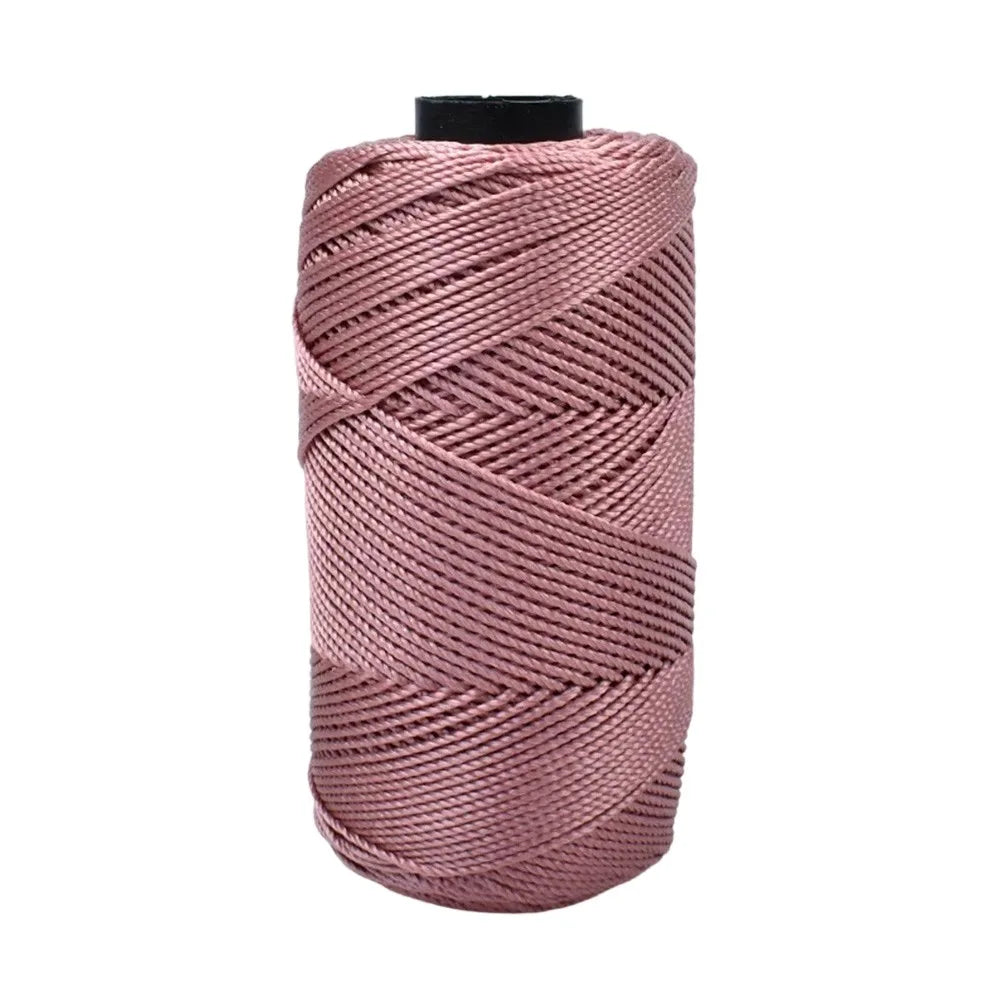 A spool of pink cotton silk thread used for knitting and crafting.
