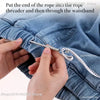 Hands are putting the end of a rope into a threader tool and then through a waistband of blue denim pants.