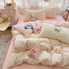 A pink polka dot duvet cover set with matching pillowcases and a small blue stuffed animal
