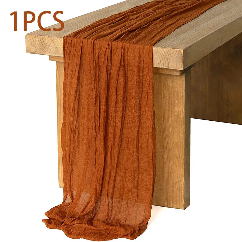 A piece of rust orange semi-sheer gauze fabric draped over a wooden table.