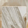 White French Rococo vintage lace curtains draped in a sheer, flowing style.