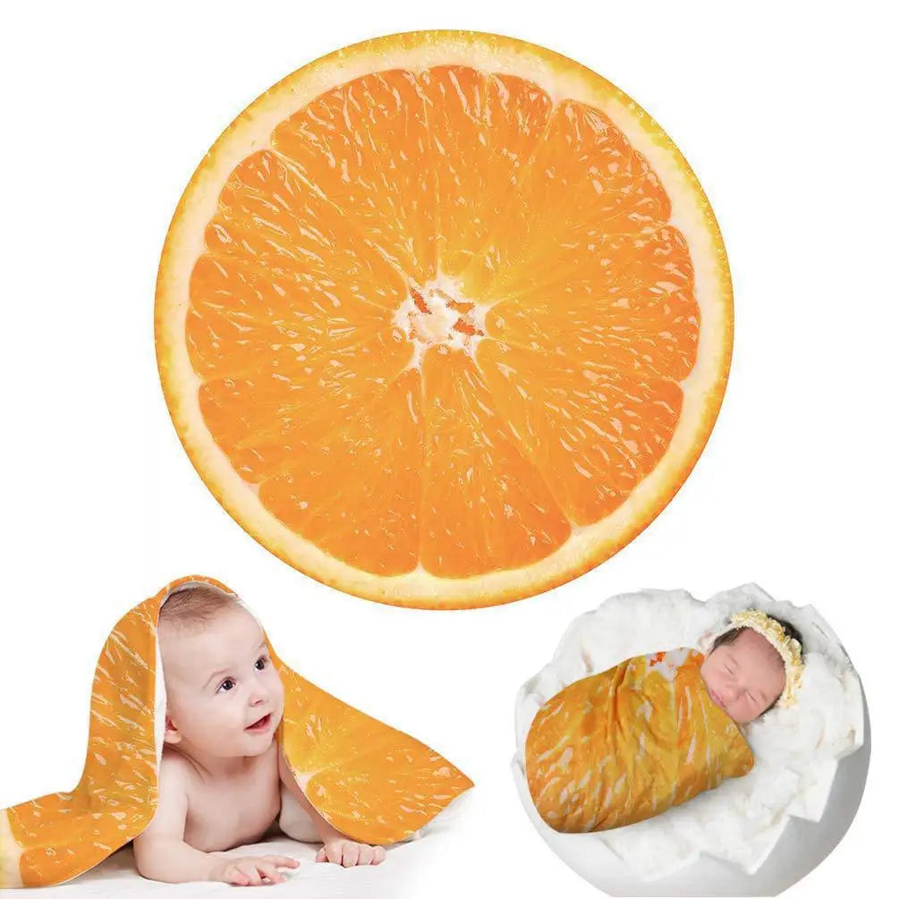 An orange citrus slice is shown next to a baby wearing an orange blanket throw.