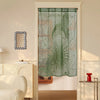 A sheer green lace door curtain with a sun and moon design hangs in a white door frame.
