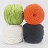 Three skeins of soft t-shirt yarn in lime green, bright orange, and black stacked together.