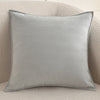 A square gray chenille throw pillow cover resting on a light-colored sofa.
