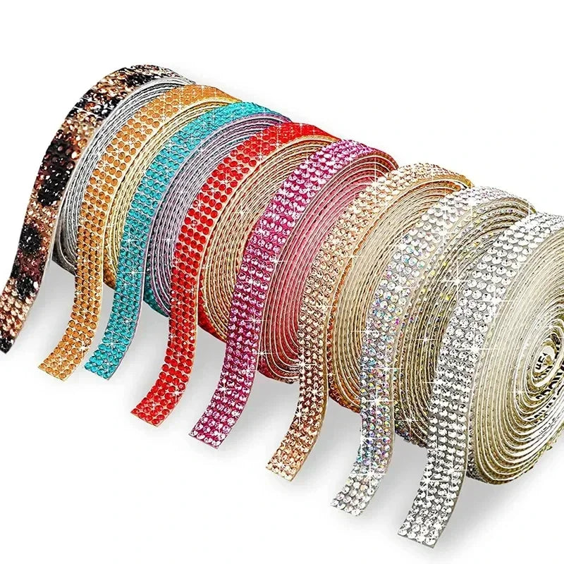 A collection of self-adhesive crystal rhinestone ribbon in various colors, laid out for DIY crafts.