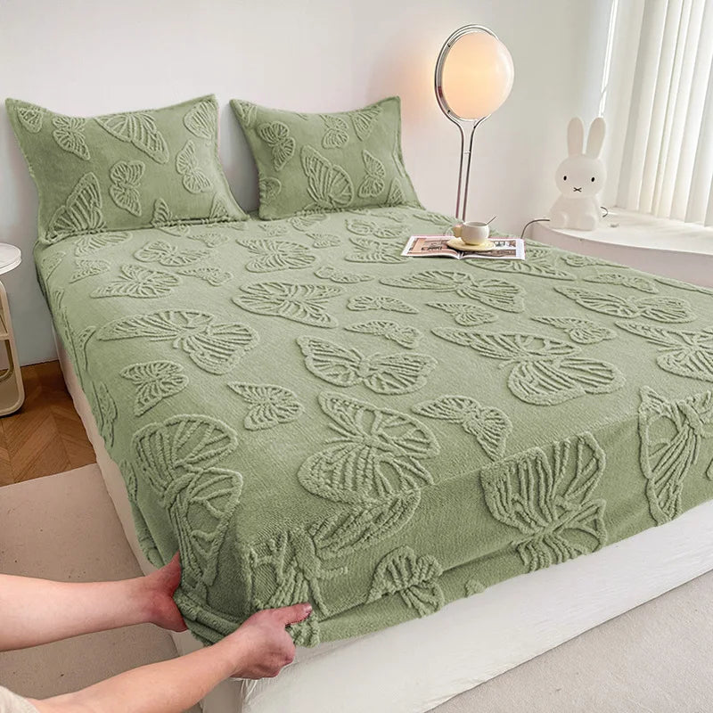 A light green jacquard weave fitted sheet bedding set on a bed with a white headboard and natural light.