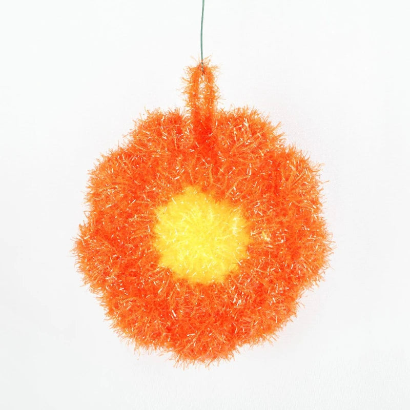 A bright orange flower-shaped kitchen dish scrubber sponge with a yellow center.