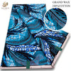 Blue and black African wax print fabric featuring leaf patterns and geometric designs.