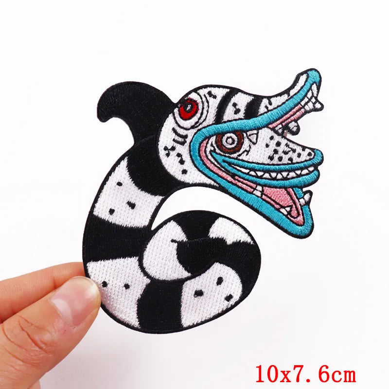 Black and white striped embroidered skull iron-on patch with blue accents