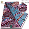 A close-up view of brown and purple African wax print fabric with intricate swirling patterns.