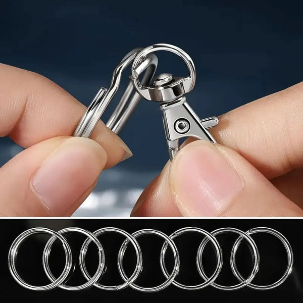 A hand is holding a silver metal snap hook and key ring, showing various sizes of circular rings.