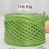 A spool of metallic green cake yarn used for crafting.