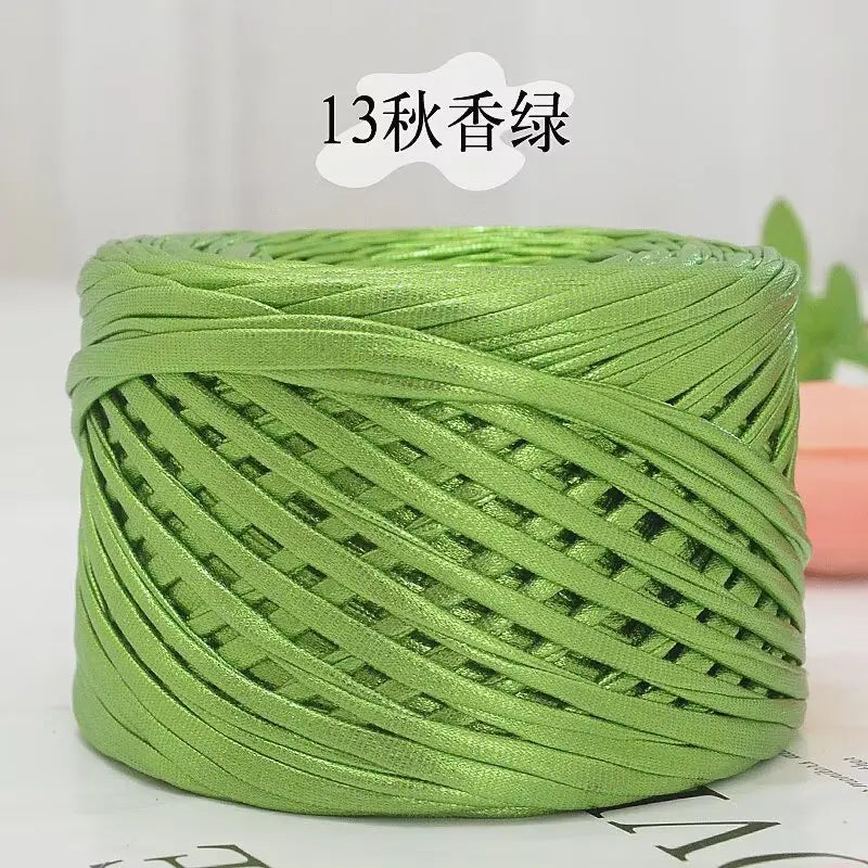 A spool of metallic green cake yarn used for crafting.
