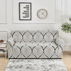 A black and white geometric pattern sofa cover protector displayed on a light gray rug.