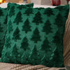A dark green knitted cushion cover featuring a repeating pattern of evergreen trees.
