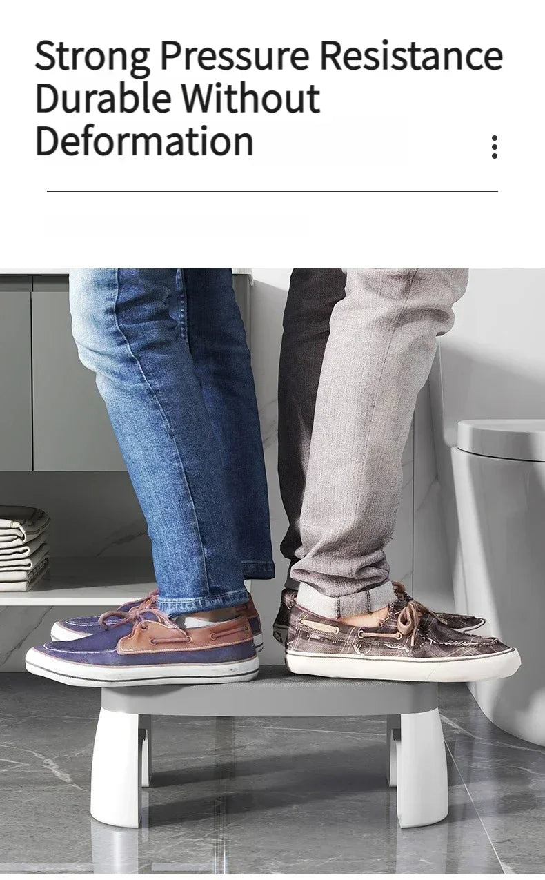 A pair of brown and gray leather dress shoes are placed on a modern stool in front of a toilet.