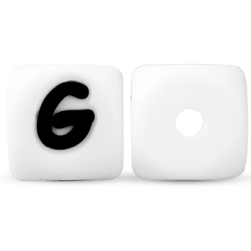A white silicone alphabet bead shaped like the letter G and another blank bead.
