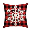A red and black plaid pillow featuring a white snowflake design.