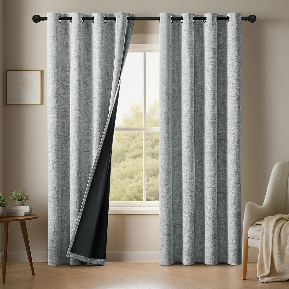Gray linen blackout curtains with a black accent panel hanging in a window frame.