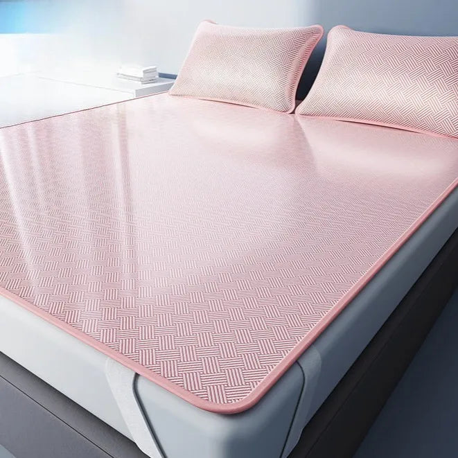 Pink cooling ice silk sheets displayed on a bed with matching pillows.