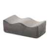 A gray ergonomic memory foam leg support pillow shown from the side.