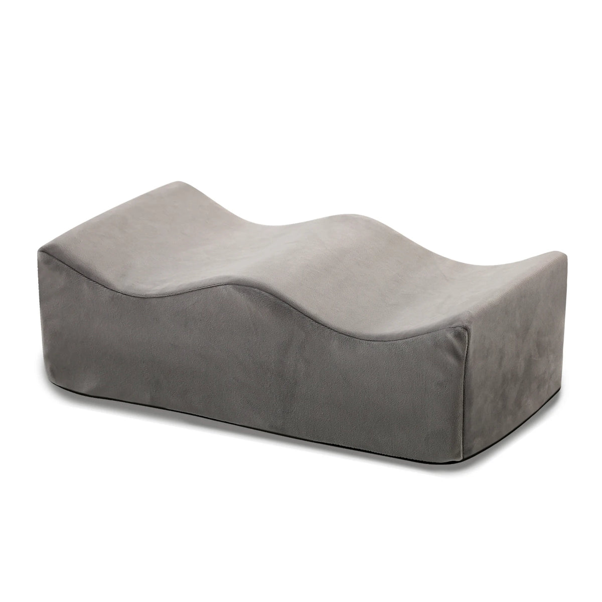 A gray ergonomic memory foam leg support pillow shown from the side.