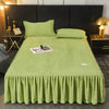 A lime green thick velvet bed skirt with pleats is displayed on a bed.