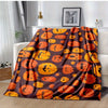 A dark brown flannel blanket featuring an orange pumpkin pattern with spider web and witch themes.