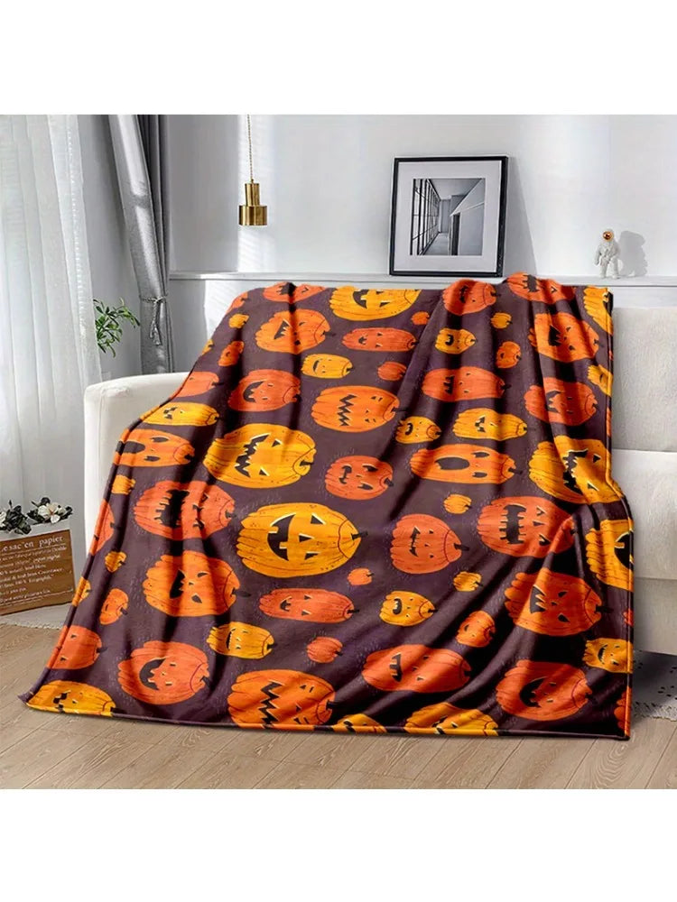 A dark brown flannel blanket featuring an orange pumpkin pattern with spider web and witch themes.