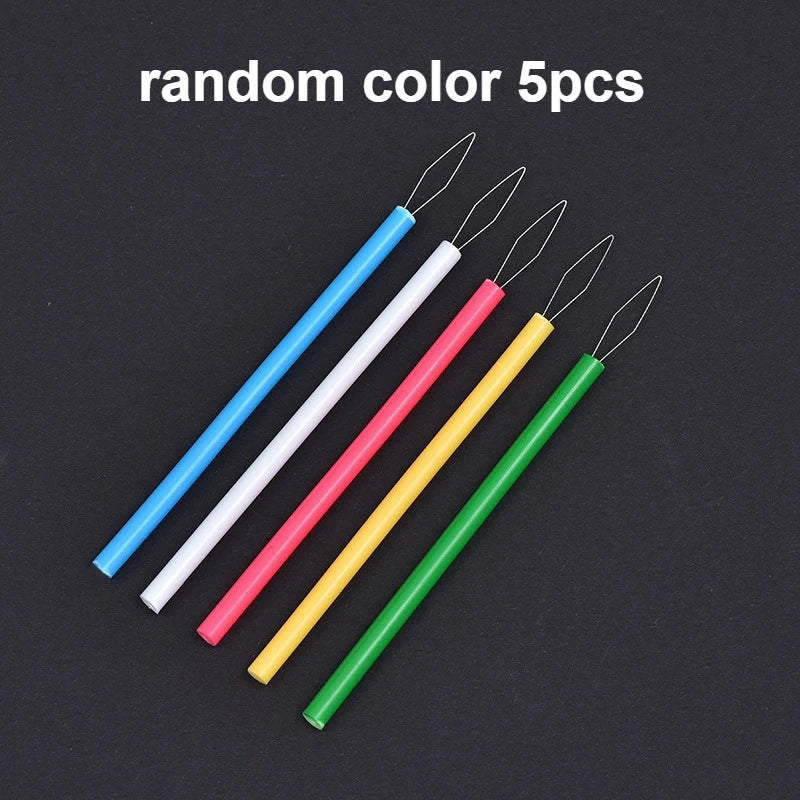 Five colorful needle threaders in blue, white, pink, yellow, and green are displayed on a dark background.