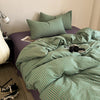 A green and white striped duvet cover set is displayed on a bed with matching pillows.