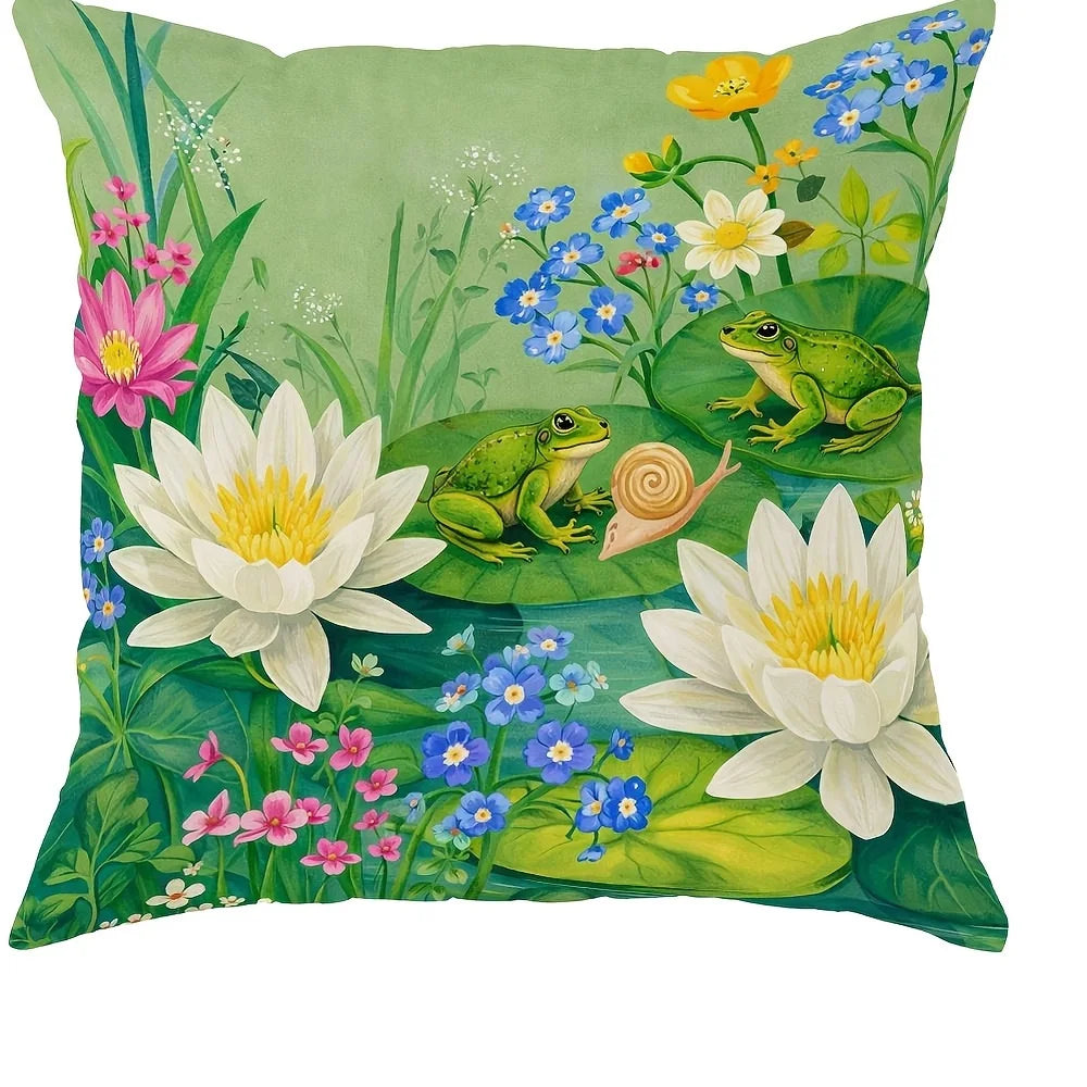 A green throw pillow featuring watercolor illustrations of wildflowers, a frog, and a snail.