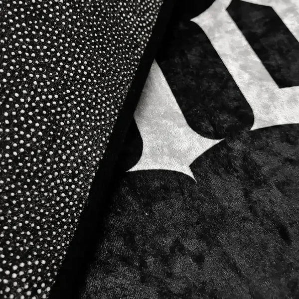 Close-up of a black carpet featuring a white coffin-shaped skeleton and spider print design.