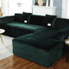 A dark emerald green velvet L-shaped sectional sofa in a modern living room setting.