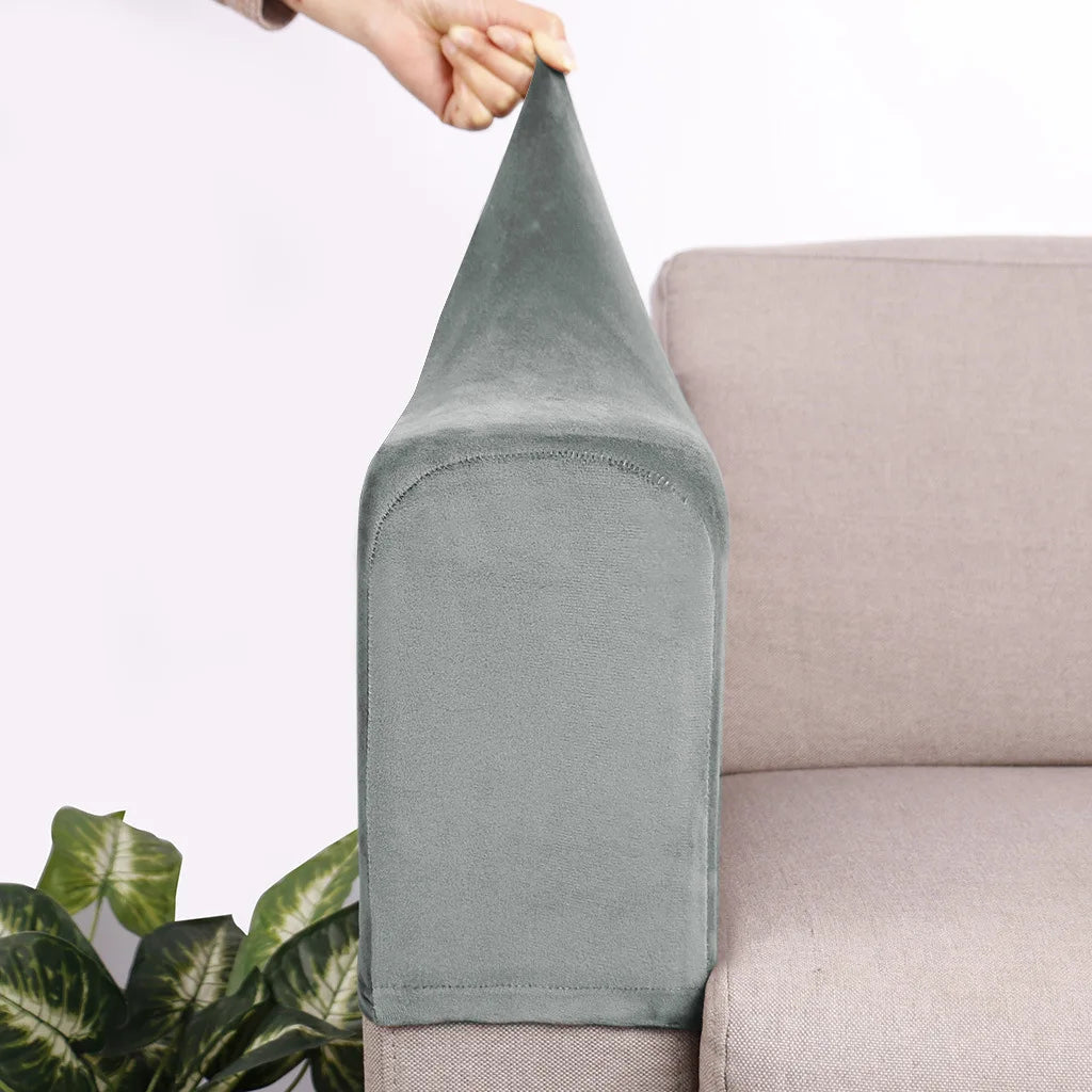 A close-up of a gray velvet sofa armrest cover being held by a hand, showing the texture and shape of the cushion.